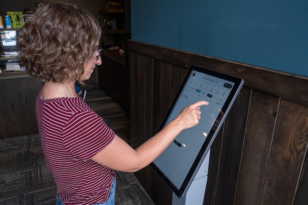 a customer shops using self service kiosk at The Botanical Co in Michigan