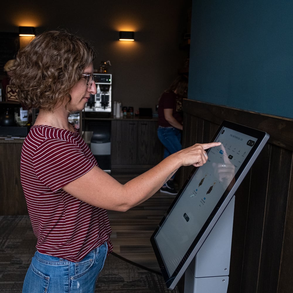 a customer uses a self ordering kiosk in a cannabis consumption lounge