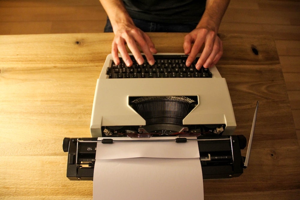 person typing on an old typewriter